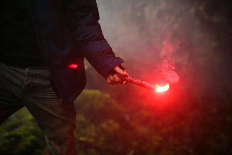 Man holding emergency communication flare in forrest